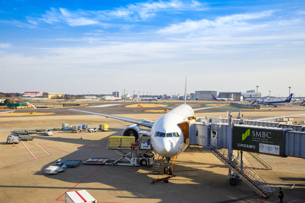 Tokyo, Japan - 24 February 2019 - Passenger airplane parks at the Tokyo International Airport waiting for passengers to board while loading its cargo in Tokyo, Japan on February 24, 2019
